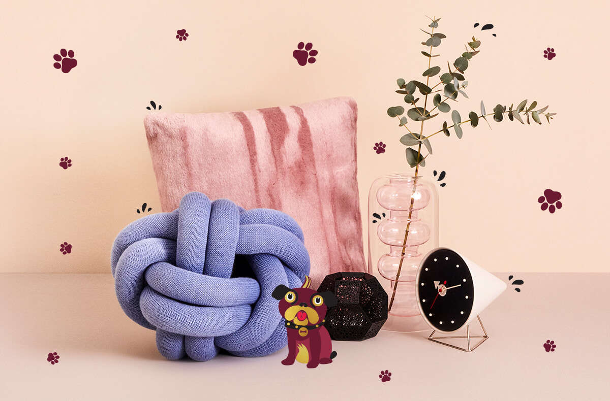 A collection of homeware products including a pink Tom Dixon cushion, vase and tea light holder
