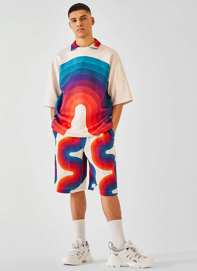 The model is wearing a Dries van Noten T-shirt, shirt and shorts with Gucci shoes