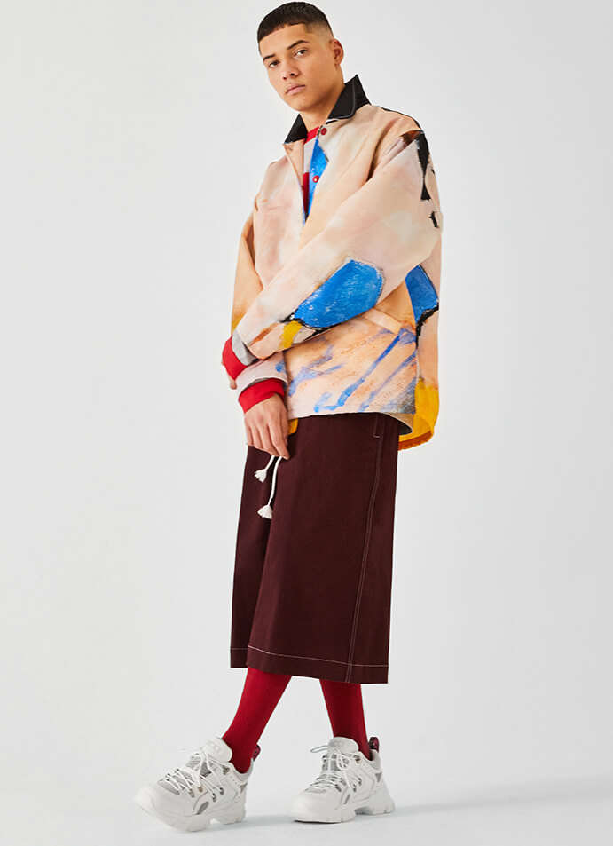 The model is wearing a Marni jacket and shorts with a pair of Gucci shoes.