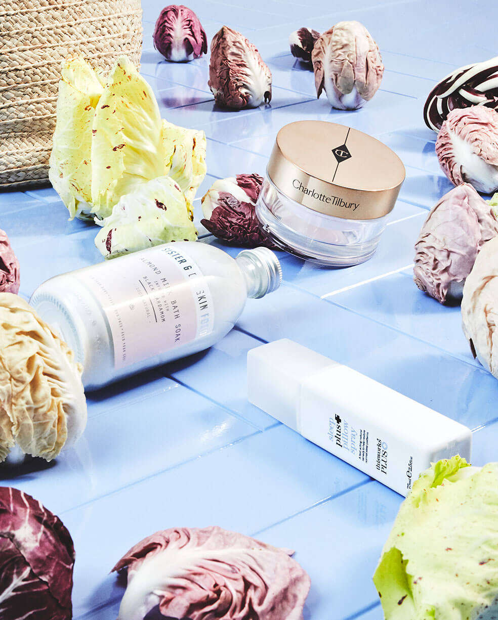 A collection of beauty products lying with cabbages