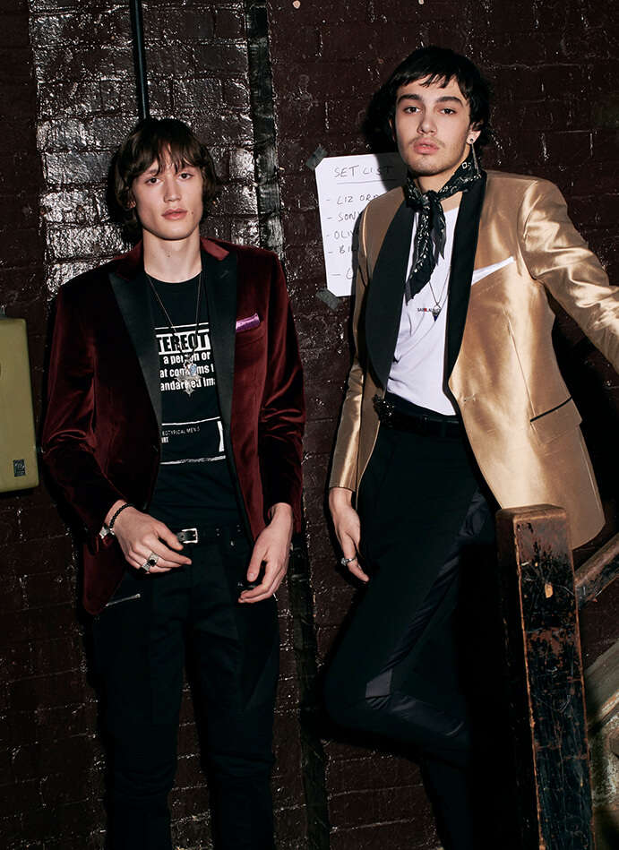 Model wearing Corneliani blazer and Maison Margiela printed T-shirt with Balmain jeans. Second model wearing Tiger of Sweden tuxedo with Saint Laurent T-shirt and Rick Owen Trousers. 